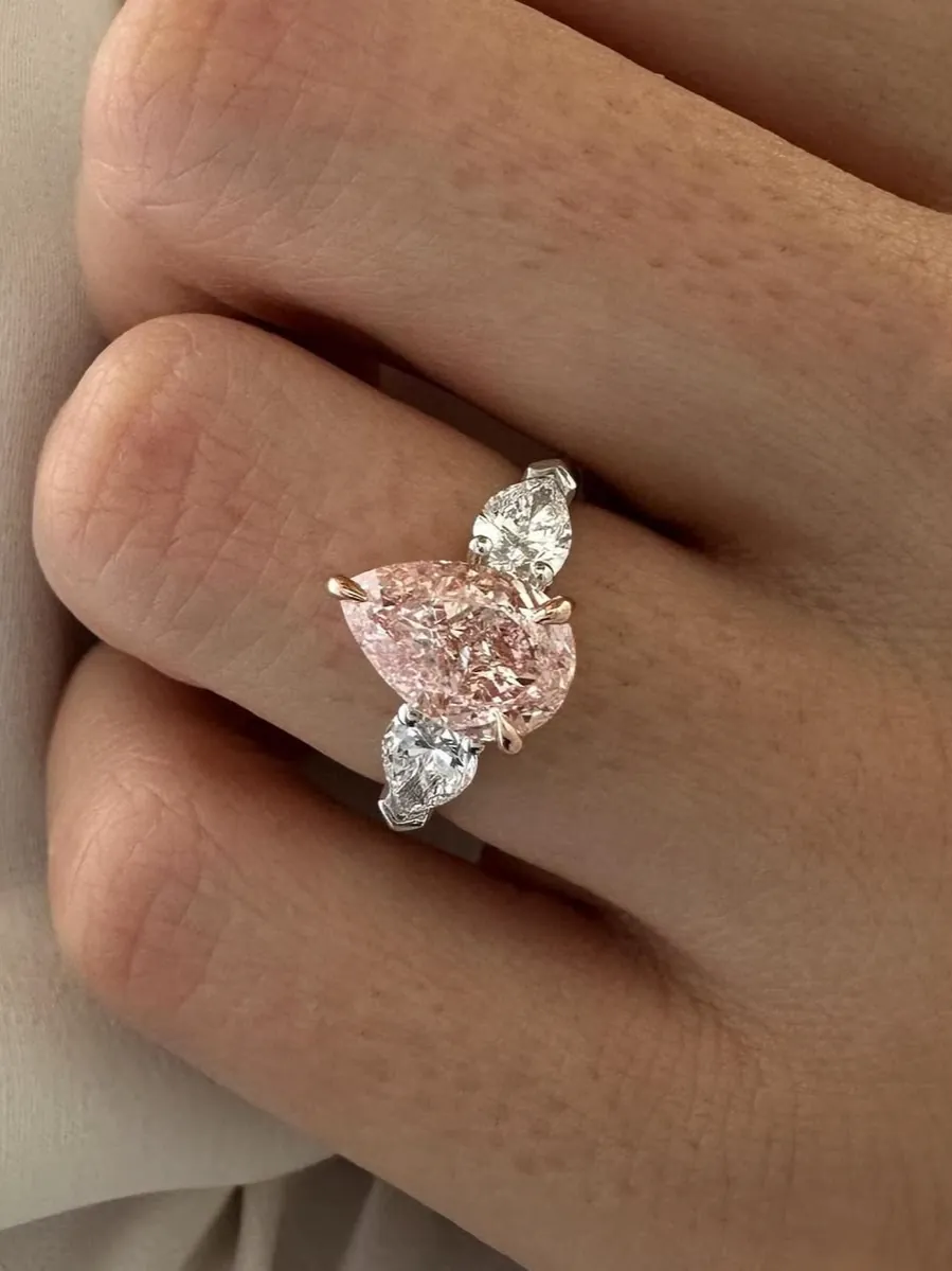 A pink pear, flanked by two smaller stones